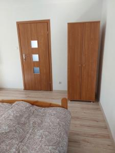 a bedroom with two wooden cabinets and a bed at Apartament Muszelka in Puck