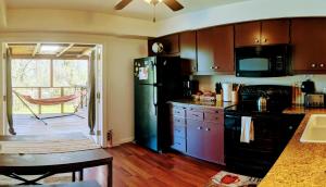 a kitchen with a black refrigerator and a table at Wona's 2 bedrooms full kitchen in Oakhurst