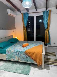 a bedroom with a bed with an orange pillow on it at Villa Saint-Paul in Pointe-Noire