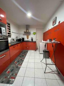 a kitchen with red cabinets and a white tile floor at Villa Saint-Paul in Pointe-Noire