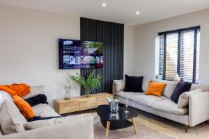 a living room with two couches and a tv at Charming 3-Bed House with 1 Parking space in Canterbury