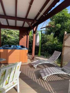 a patio with a hot tub and chairs on a deck at Villa Saint-Paul in Pointe-Noire
