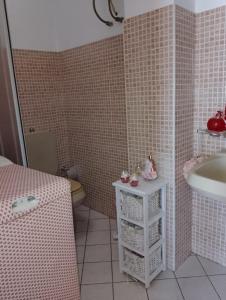 ein rosa gefliestes Bad mit einem Waschbecken und einem WC in der Unterkunft Casa panoramica in Mascali