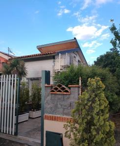 ein Haus mit einer Steinmauer und einem Zaun in der Unterkunft Casa panoramica in Mascali