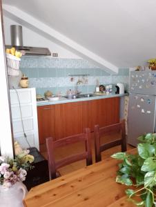 una cucina con tavolo, lavandino e frigorifero di Casa panoramica a Mascali