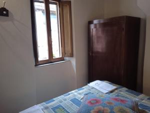 1 dormitorio con 1 cama con ventana y vestidor en La casa di Daisy, en Pitigliano