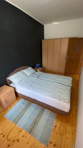 a bed in a room with a wooden floor at Apartman Down Town in Sremska Mitrovica