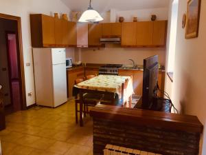 a kitchen with a table and a white refrigerator at Mo.Da' Apartments in San Marino