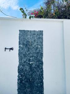 a white wall with a rock wall at Casa de la Amor Casita in Pedasí Town