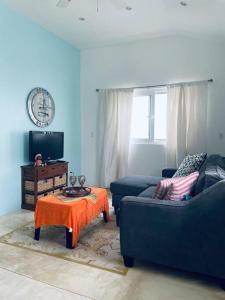 una sala de estar con 2 sofás azules y una mesa. en Casa de la Amor Casita, en Pedasí Town