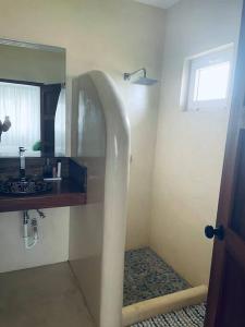 W łazience znajduje się umywalka i lustro. w obiekcie Casa de la Amor Casita w mieście Pedasí Town