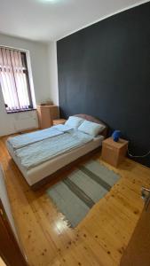 a bedroom with a bed and two boxes on the floor at Apartman Down Town in Sremska Mitrovica