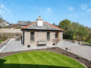 a stone house with a bench in a yard at The Outhouse in Kendal