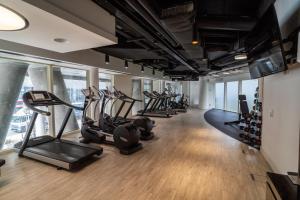 einen Fitnessraum mit mehreren Laufbändern und Crosstrainern in der Unterkunft Luxury 2-Bed Croydon Apartment Near Gatwick in Croydon