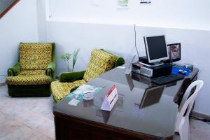 een bureau met een computer en 2 stoelen bij Hotel Gold Fénix in Tunja