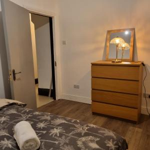 a bedroom with a bed and a dresser with a mirror at 41 Crawley Road in Luton