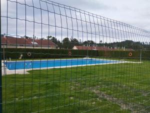 a tennis court is seen through a fence at Apartamento Morriña in Brion