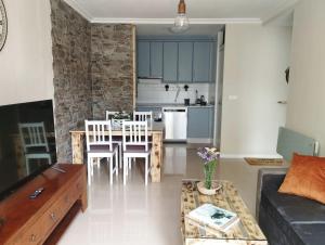 a living room with a table and chairs and a kitchen at Apartamento Morriña in Brion