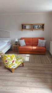 sala de estar con sofá naranja y cama en Apartment Fritali, en Tadten