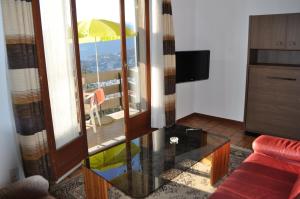 a living room with a glass table with a view of a balcony at Appartamenti Fortunella in Lugano