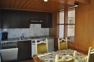 a kitchen with a table and a sink and a stove at Appartamenti Fortunella in Lugano