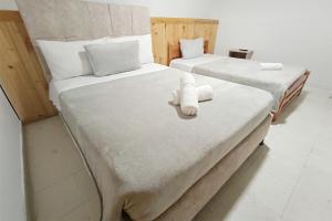 two beds with towels on them in a room at Hotel Gold Fénix in Tunja