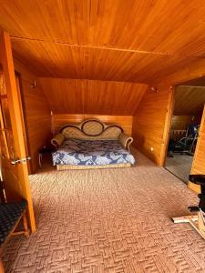 a bedroom with a bed in a wooden room at Cottage 'Carolina' with hot tub, sauna and BBQ area in Kosiv