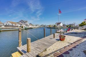 a wooden dock with a flag on top of the water at Toms River Apartment with On-Site Canal Access! in Toms River