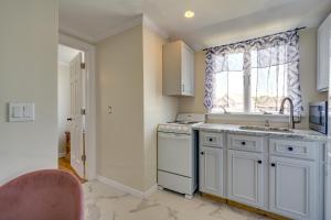 a kitchen with white cabinets and a sink and a window at Toms River Apartment with On-Site Canal Access! in Toms River