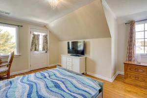 a bedroom with a bed and a desk and windows at Toms River Apartment with On-Site Canal Access! in Toms River
