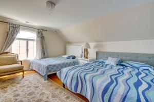 a bedroom with two beds and a chair and a window at Toms River Apartment with On-Site Canal Access! in Toms River