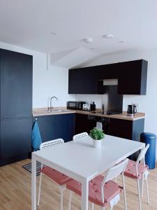 cocina con mesa blanca y sillas en Modern House, en Mánchester