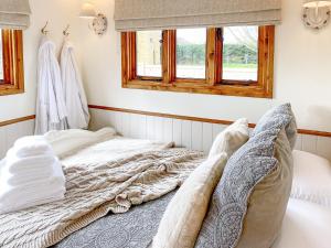 an unmade bed in a room with a window at Little Norfolk Cabin in Neatishead
