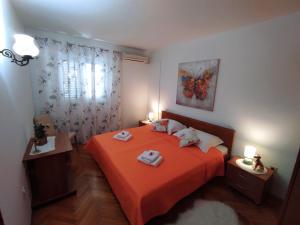 a bedroom with a orange bed with two towels on it at Apartments Marija Lapad in Dubrovnik