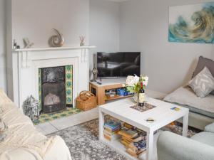 a living room with a fireplace and a tv at Dune-cottage in Caister-on-Sea