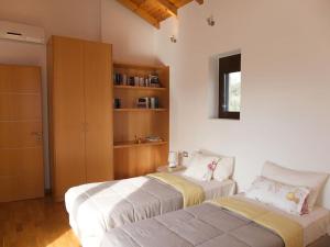 a bedroom with two beds and a book shelf at Stone Villa Analisa, Pool, BBQ, Sunset Sea view in Kondomárion