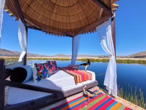 uma cama num gazebo sobre um corpo de água em Uros Lodge Perú em Puno