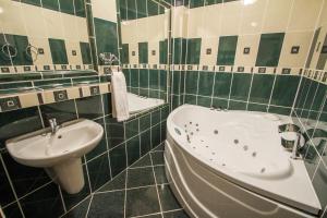 a green and white bathroom with a tub and a sink at Hotel Grand in Žilina +31 photos