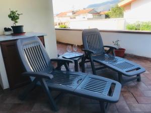 2 Stühle und ein Tisch auf der Terrasse in der Unterkunft Mondello Aiace 40 in Mondello