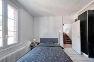een slaapkamer met een groot bed en een raam bij Magnifique maison pleine de charme ideale jeux olympiques un kilometre de la gare in Évreux