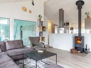 a living room with a couch and a fireplace at Holiday Home Falkevej IV in Terpet