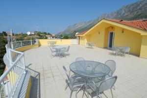 a patio with tables and chairs on a balcony at Apartments Vesna in Gradac