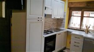 uma cozinha com armários brancos e um forno com placa de fogão em Casa Coccinella Valdieri - Codice CIR00423300008 em Valdieri
