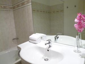 La salle de bains est pourvue d'un lavabo blanc et d'une baignoire. dans l'établissement Appart'City Classic Aix en Provence - Fuveau, à Fuveau