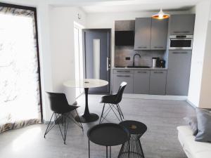 een keuken en een woonkamer met een tafel en stoelen bij Sea View Garden Apartment K2 in Rabac