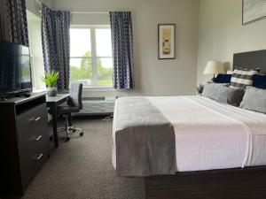 a bedroom with a bed and a desk and a television at Brinton Suites in West Chester