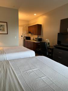 a hotel room with two beds and a kitchen at Brinton Suites in West Chester