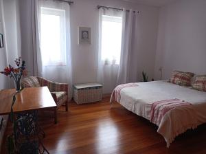 普拉亞達維多利亞的住宿－Valmoa T4，一间卧室配有一张床、一张沙发和两个窗户。