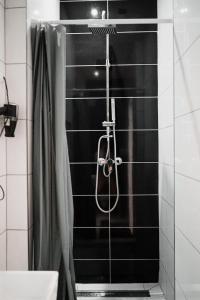 La salle de bains est pourvue d'une douche et de carrelage noir. dans l'établissement Downtown studios Budapest, à Budapest
