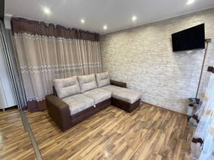 ein Wohnzimmer mit einem Sofa und einem Flachbild-TV in der Unterkunft 1-комнатная квартира - студия в центре города! in Petropawlowsk